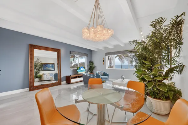 a dining room with furniture a potted plant and a chandelier