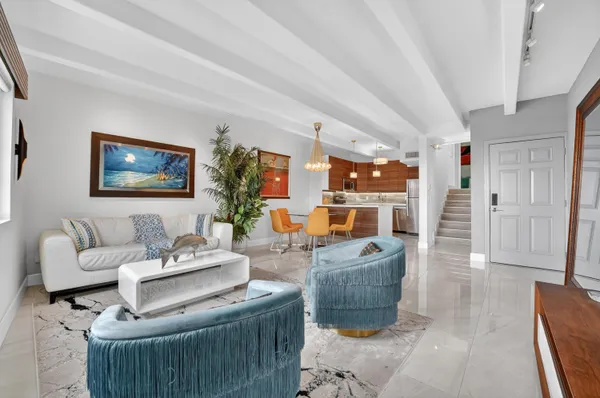 a living room with furniture a flat screen tv and a large window