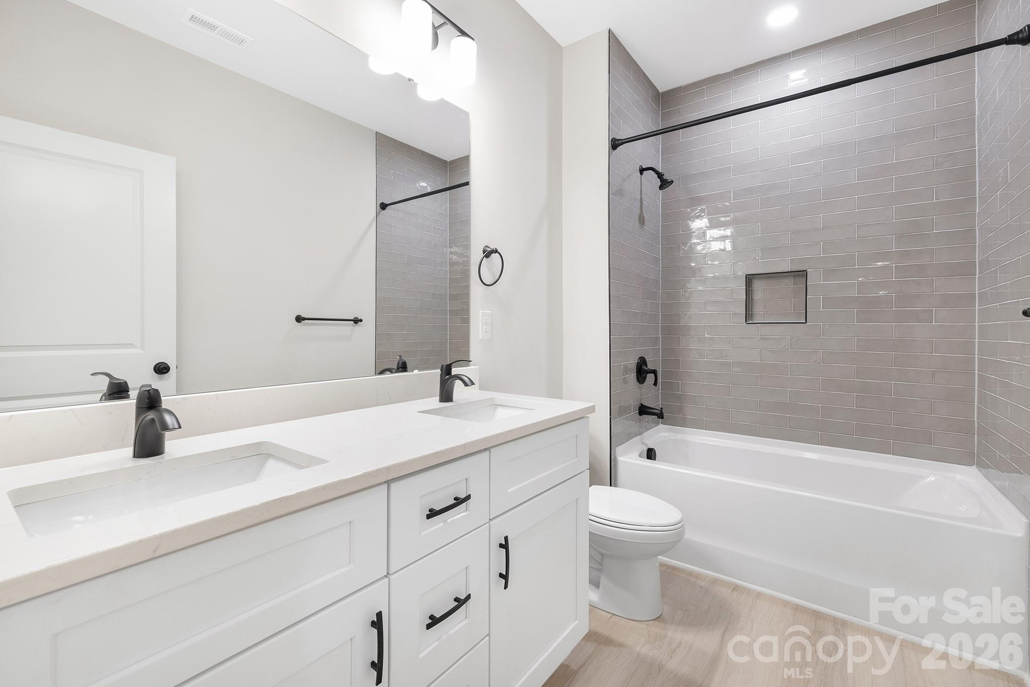 4015 Oakdale Road Charlotte, NC 28216 - Photo 15 of 30 a bathroom with a granite countertop sink a toilet and a bathtub