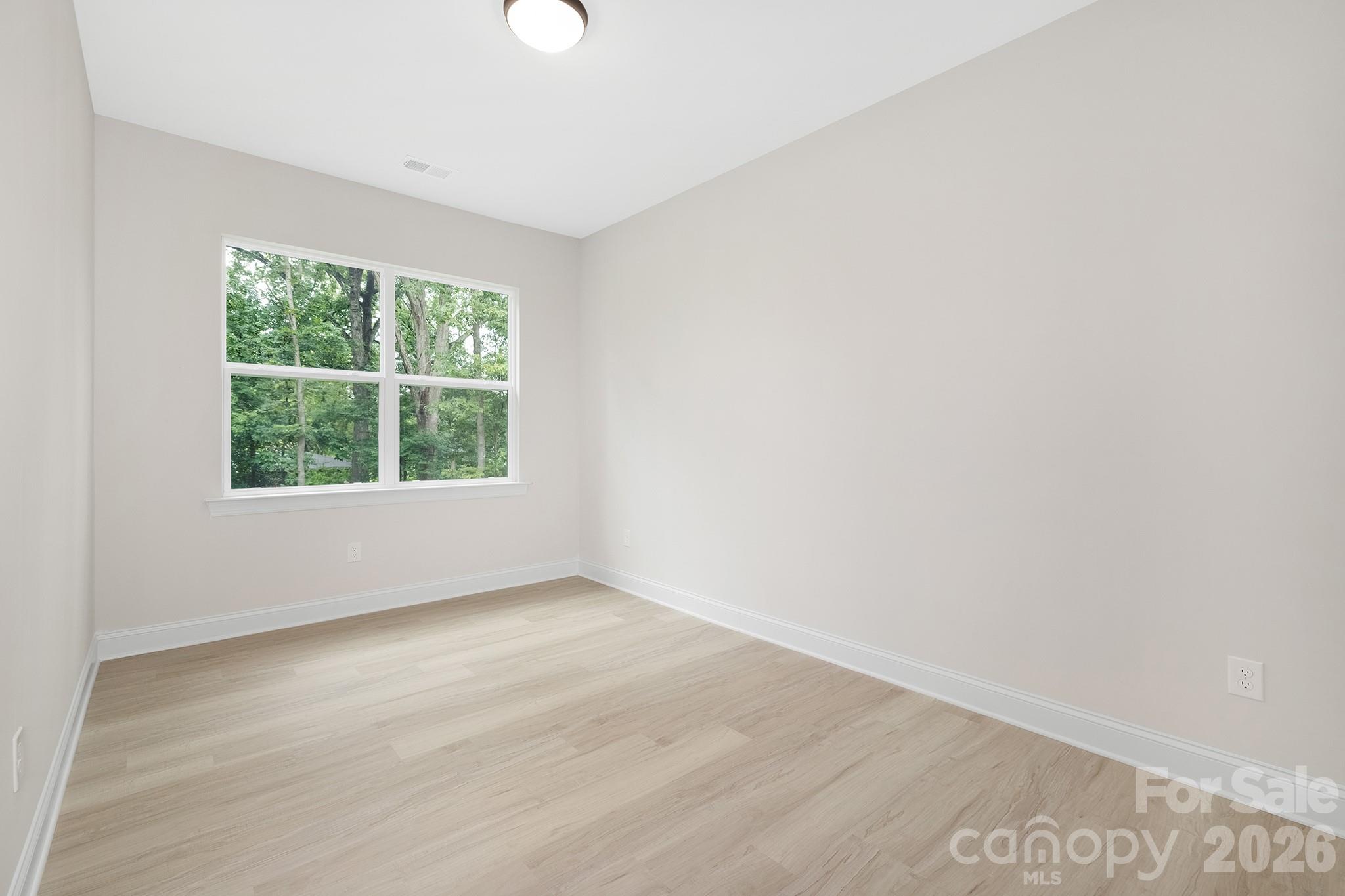 4015 Oakdale Road Charlotte, NC 28216 - Photo 16 of 30 an empty room with wooden floor and windows