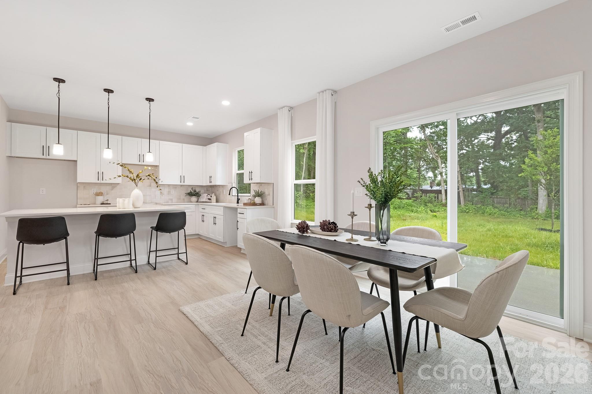 4015 Oakdale Road Charlotte, NC 28216 - Photo 7 of 30 a kitchen with a table chairs and a wooden floor