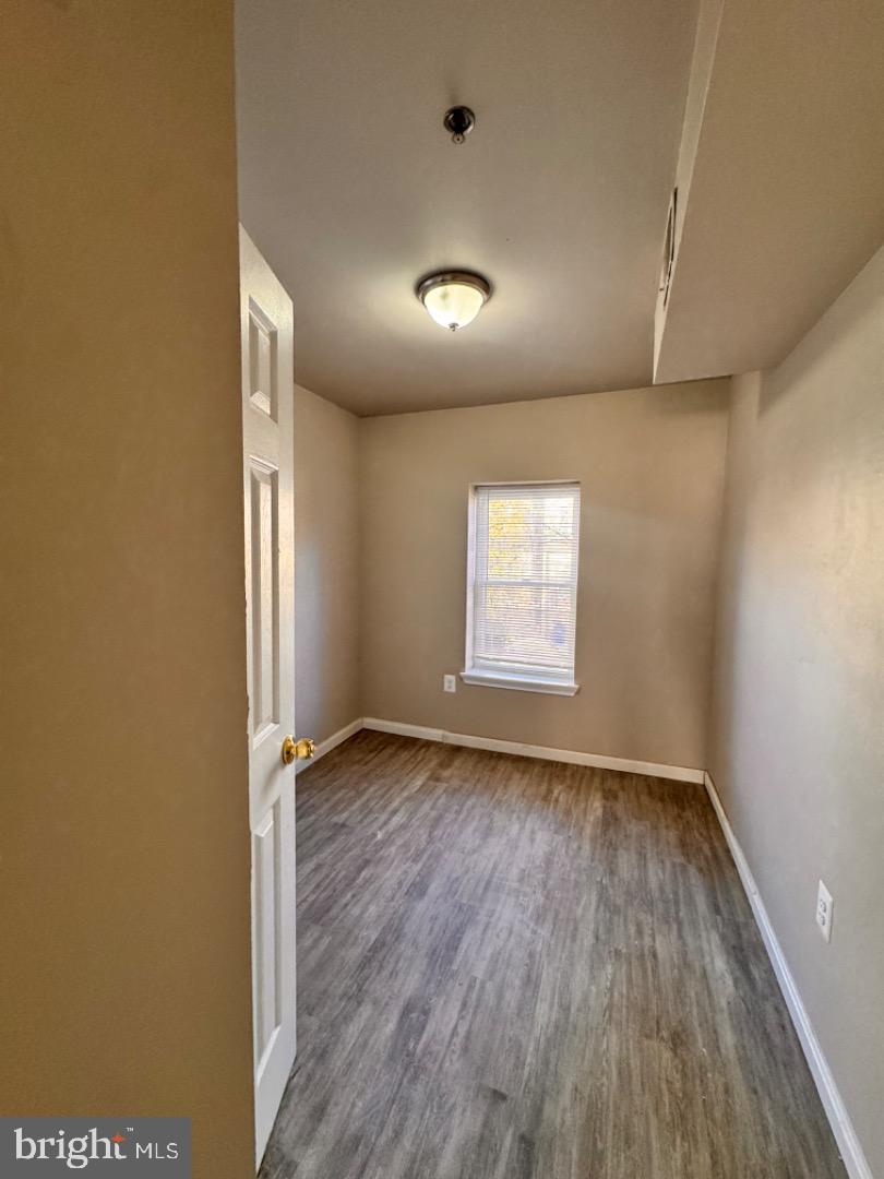 1020 Bennett Place Baltimore, MD 21223 - Photo 8 of 8 an empty room with wooden floor and windows