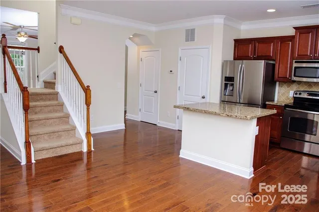 a kitchen with stainless steel appliances granite countertop a refrigerator microwave and stove