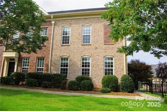 a front view of a house with a yard and plants