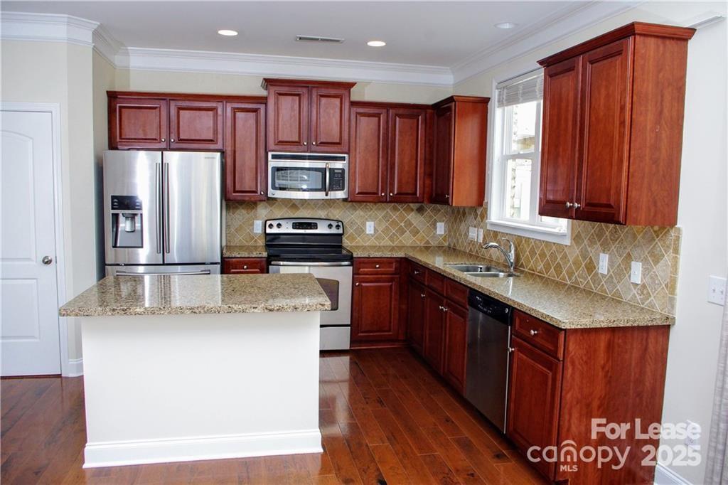 916 Gardners Way Cornelius, NC 28031 - Photo 10 of 35 a kitchen with stainless steel appliances granite countertop a refrigerator a stove top oven a sink and dishwasher