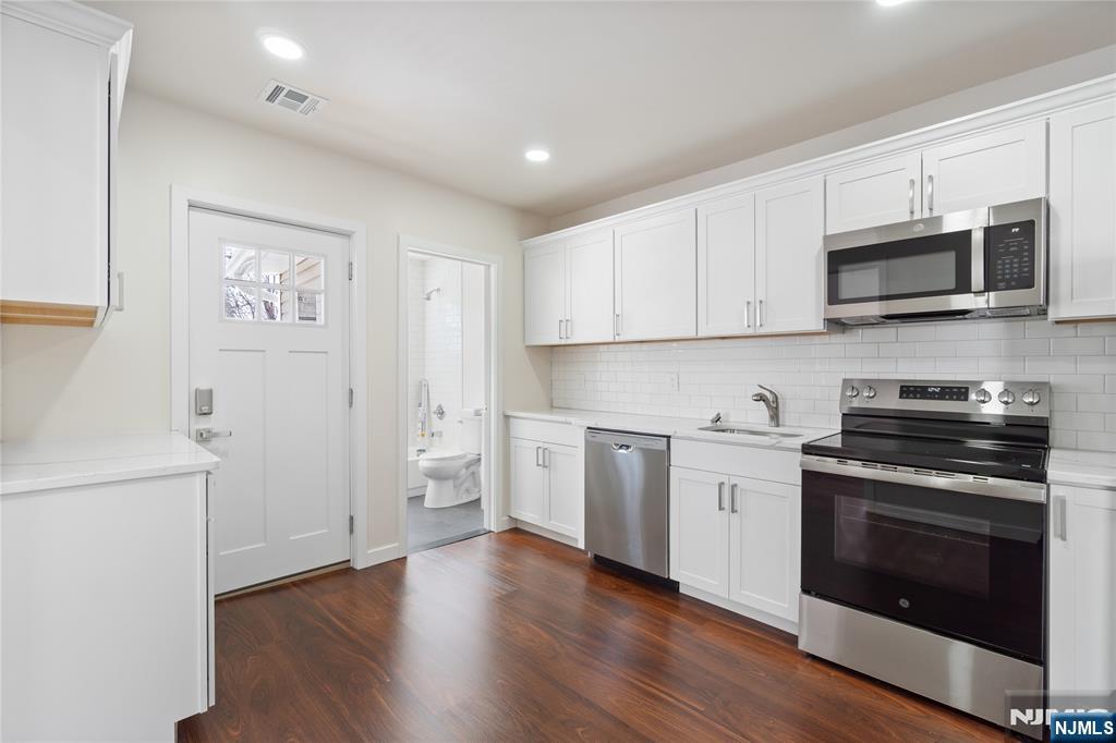 826 George Street, Unit 2 Plainfield, NJ 07062 - Photo 8 of 30 a kitchen with stainless steel appliances white cabinets and a stove top oven