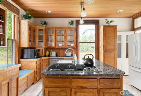 a kitchen with stainless steel appliances granite countertop a stove a sink and a granite island