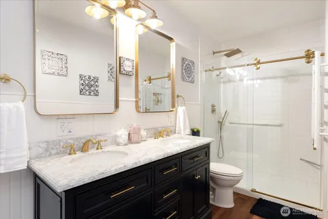 a bathroom with a granite countertop sink toilet and shower