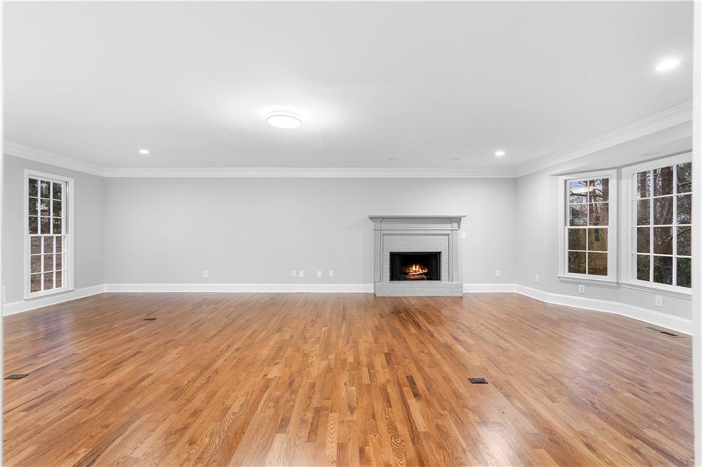 3907 Brinton Mill Road Marietta, GA 30062 - Photo 14 of 61 an empty room with wooden floor and fireplace