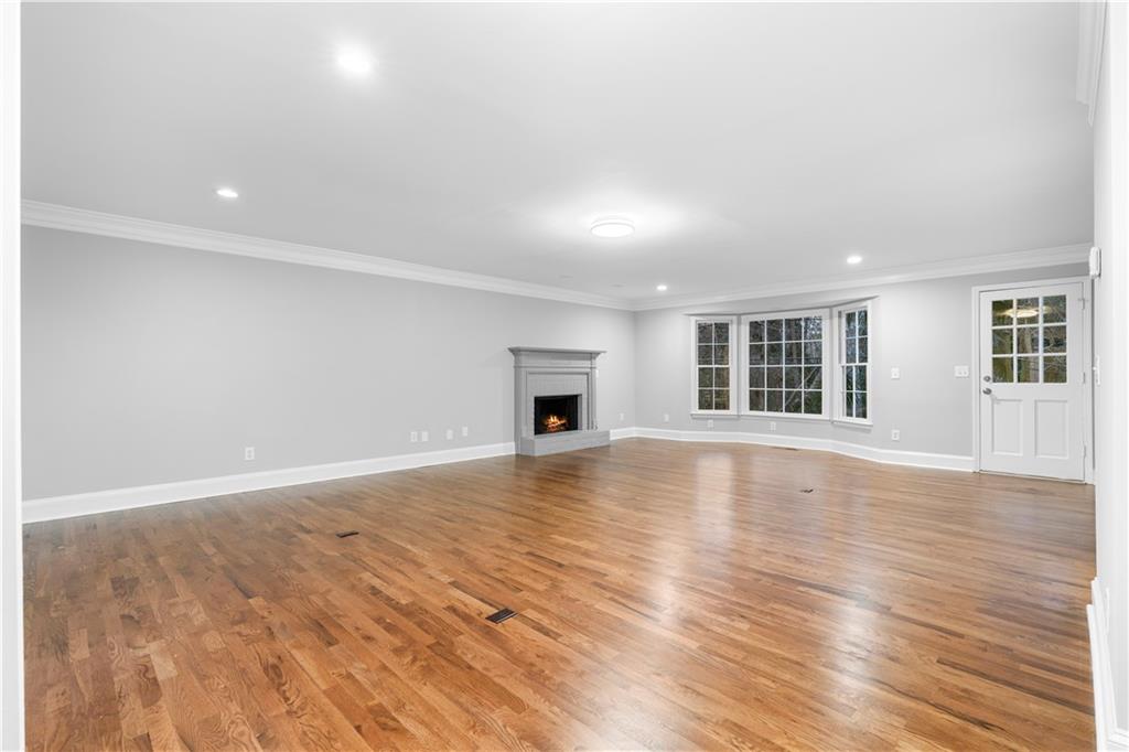 3907 Brinton Mill Road Marietta, GA 30062 - Photo 8 of 61 an empty room with wooden floor and fireplace