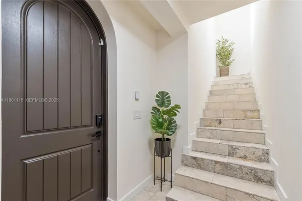 a view of staircase with white walls and a potted plant