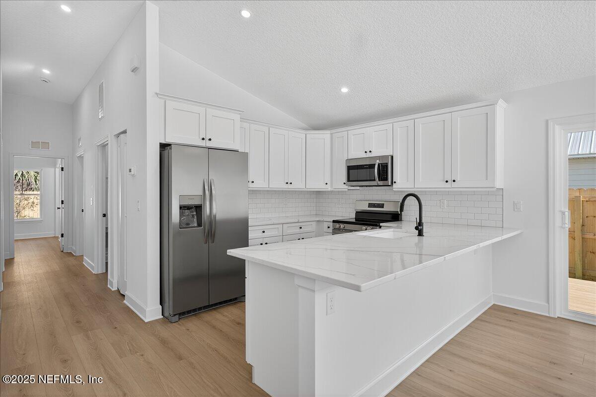 69 Josiah Street St. Augustine, FL 32084 - Photo 10 of 50 a large kitchen with stainless steel appliances a refrigerator and a stove top oven