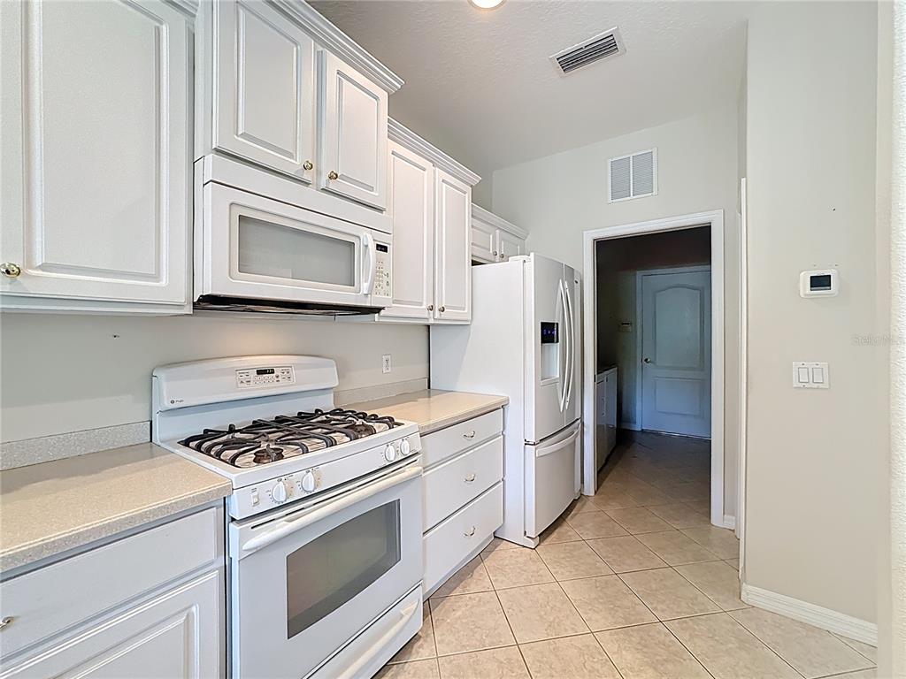 8721 Stone Harbour Loop Bradenton, FL 34212 - Photo 18 of 71 a kitchen with cabinets stainless steel appliances and a window