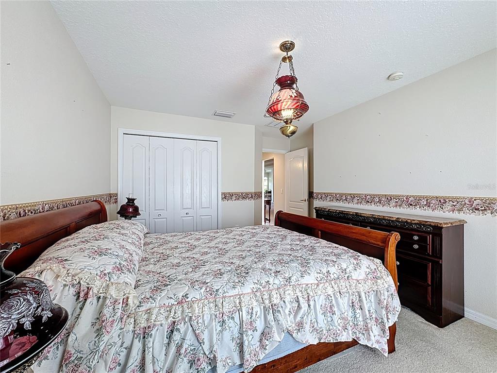 8721 Stone Harbour Loop Bradenton, FL 34212 - Photo 29 of 71 a bedroom with a bed and a chandelier