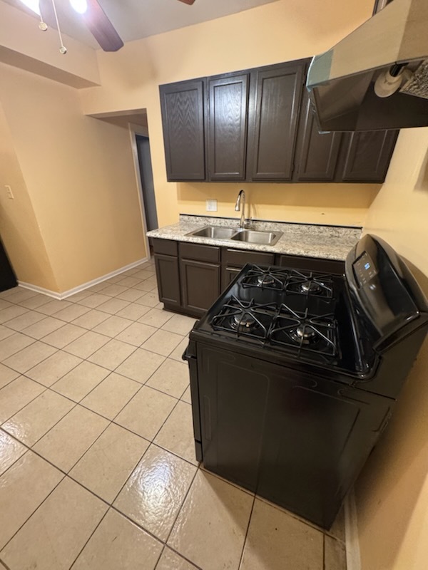 2908 West Fillmore Street, Unit 2 Chicago, IL 60612 - Photo 4 of 7 a kitchen with a black stove and white cabinets