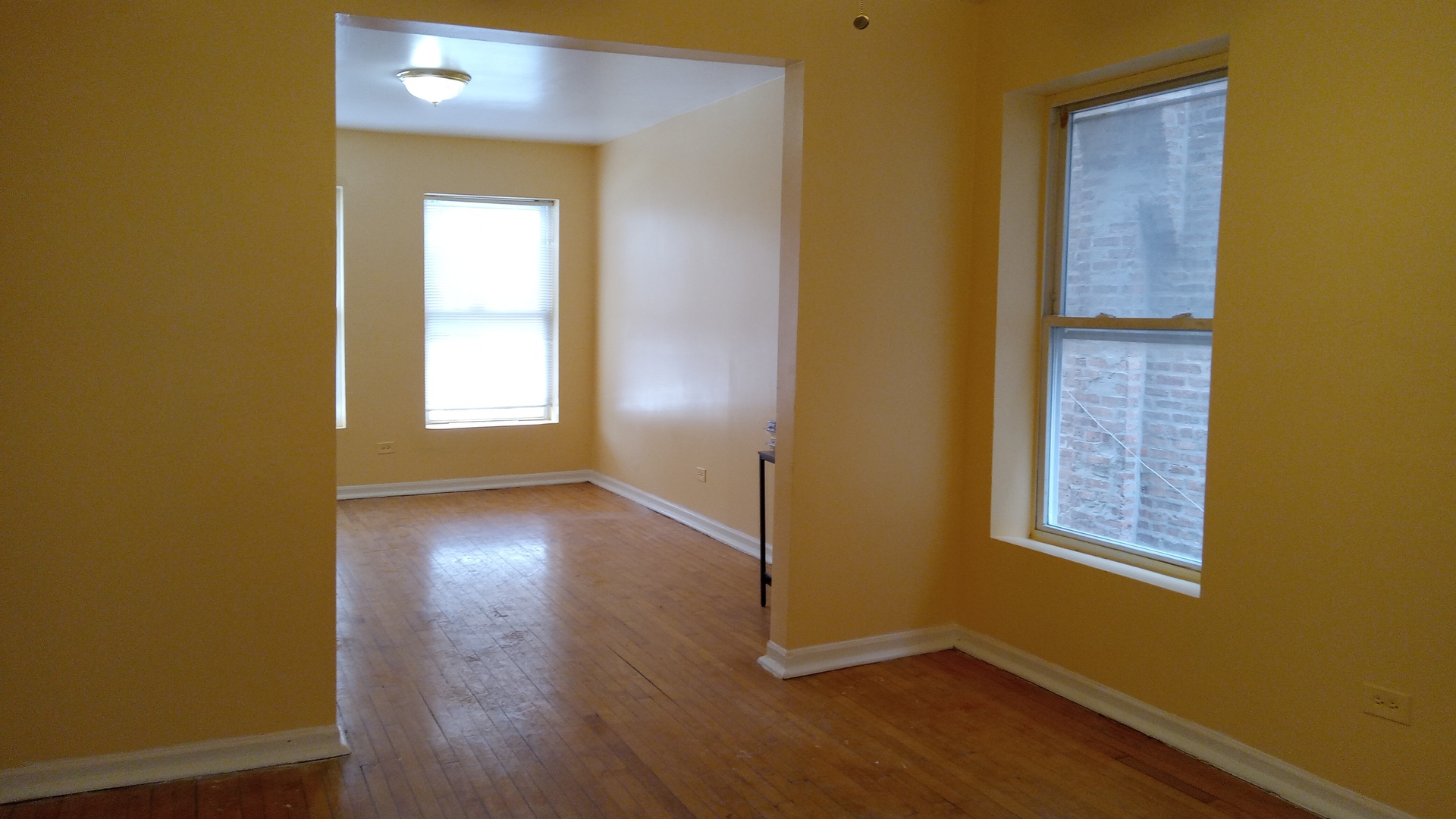 2908 West Fillmore Street, Unit 2 Chicago, IL 60612 - Photo 5 of 7 a view of an empty room with wooden floor and a window