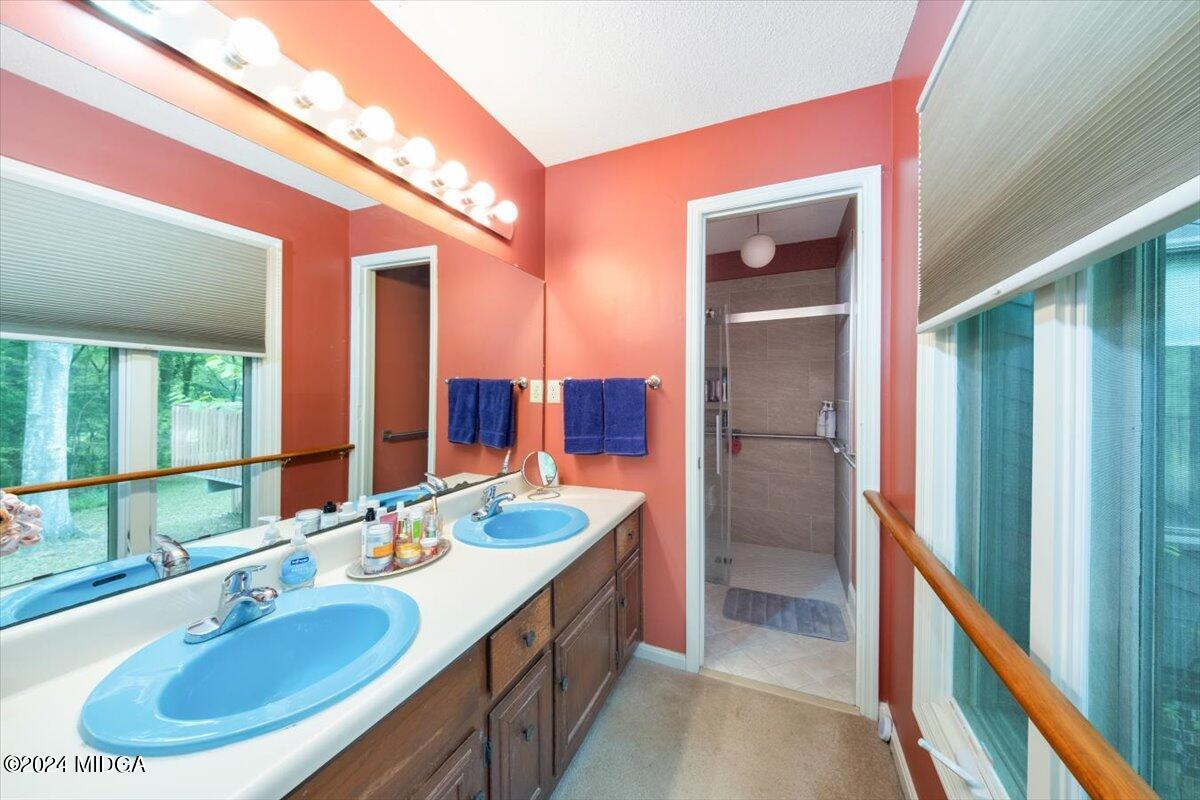 5157 Zebulon Road Macon, GA 31210 - Photo 17 of 34 a bathroom with a double vanity sink and a large mirror
