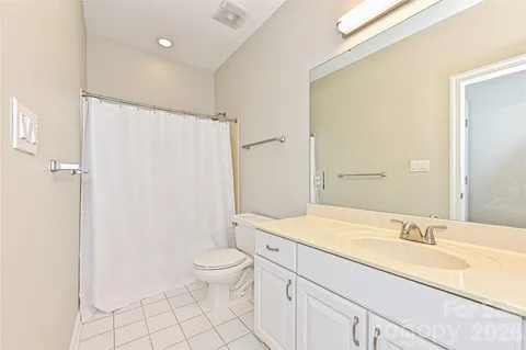 a bathroom with a sink a toilet and a large mirror