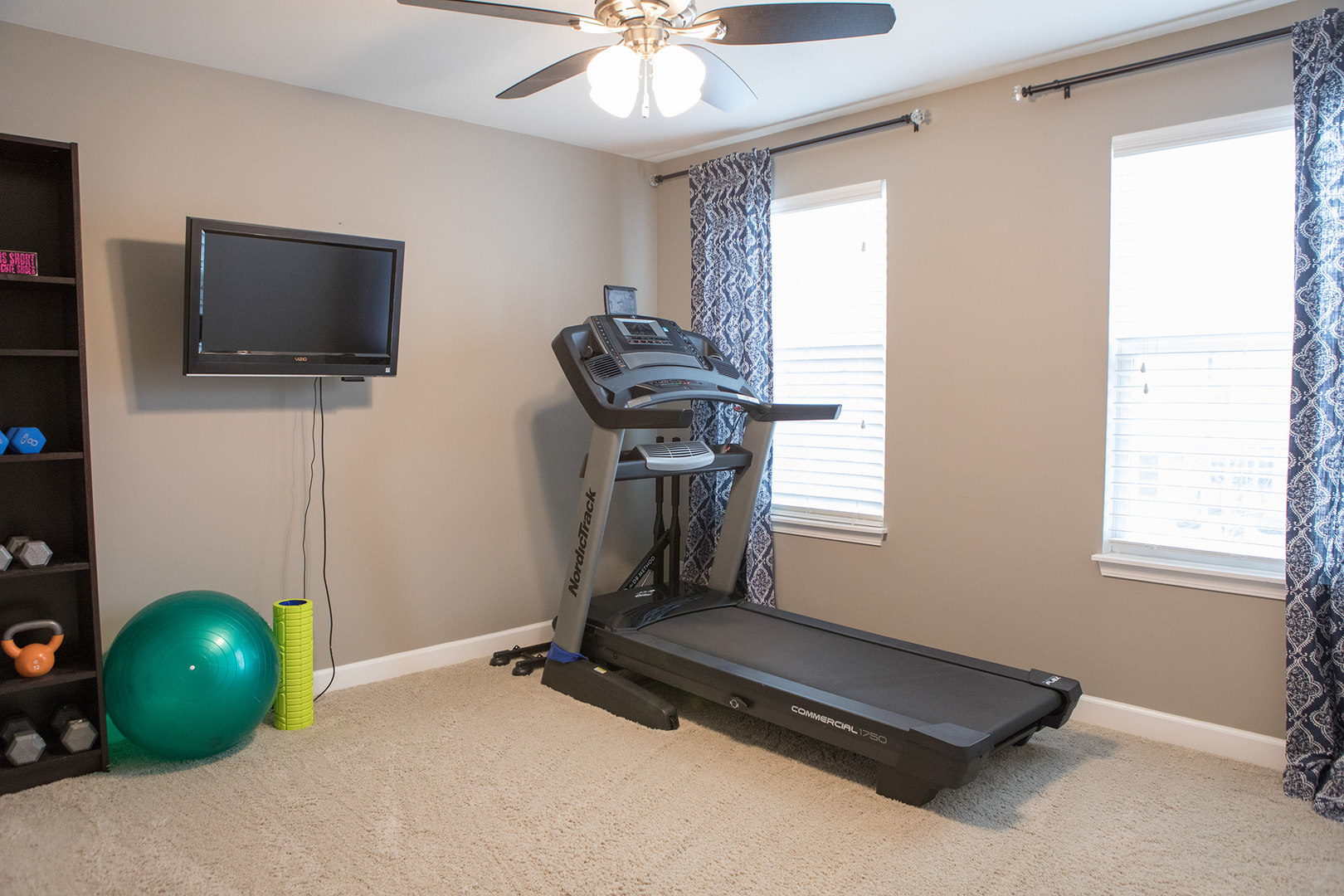 5718 Oak Ridge Way Lisle, IL 60532 - Photo 20 of 29 a room with gym equipment and a flat screen tv