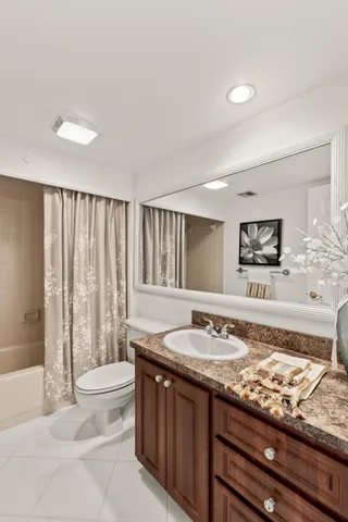 a bathroom with a granite countertop sink and a large mirror