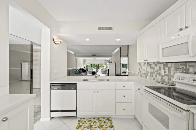 a kitchen with white cabinets and white appliances