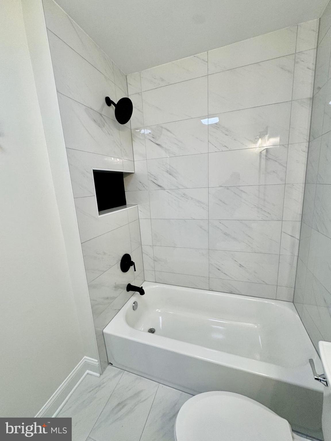 7023 Dolphin Road Lanham, MD 20706 - Photo 19 of 47 a bathroom with a bathtub and a shower