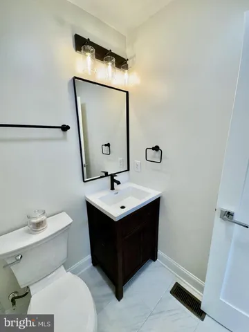 a bathroom with a sink toilet and mirror
