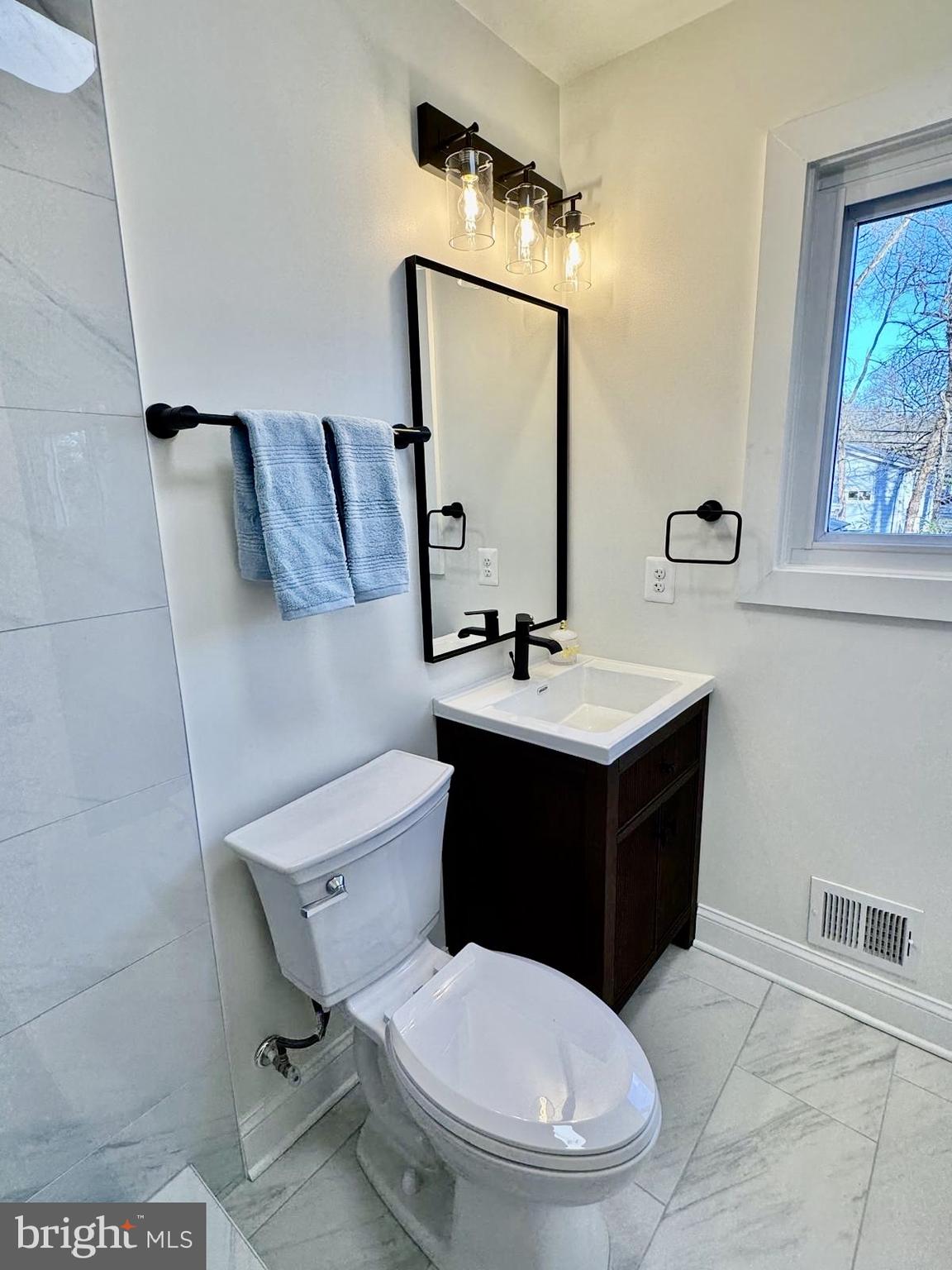 7023 Dolphin Road Lanham, MD 20706 - Photo 24 of 47 a bathroom with a toilet sink vanity and mirror