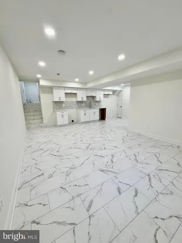 a large white kitchen with granite countertop a sink and a white stove