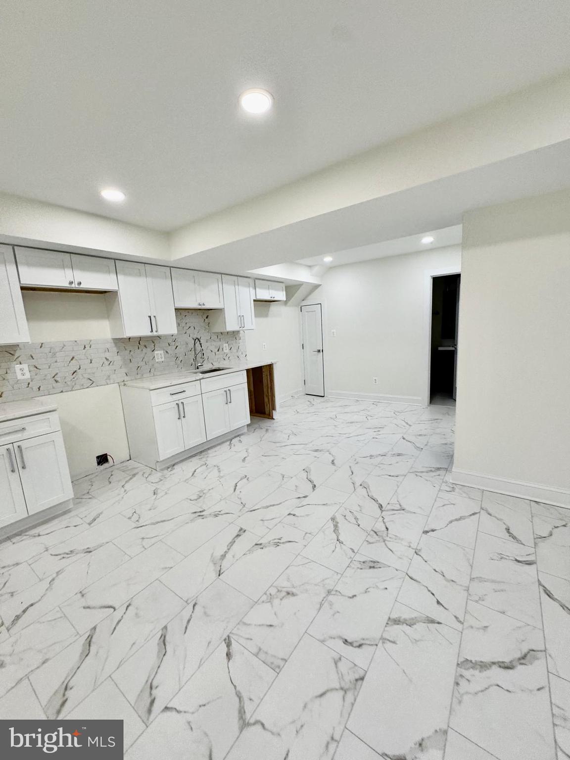 7023 Dolphin Road Lanham, MD 20706 - Photo 34 of 47 a large white kitchen with granite countertop a sink and a white stove