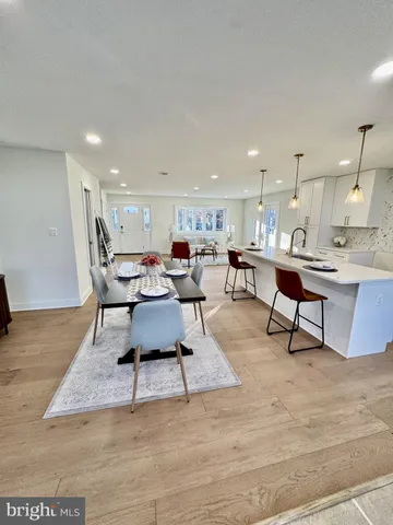 a living room with lots of furniture a table and kitchen view