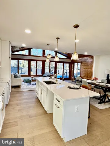 a large kitchen with kitchen island a large counter top a sink a stove and a wooden floors