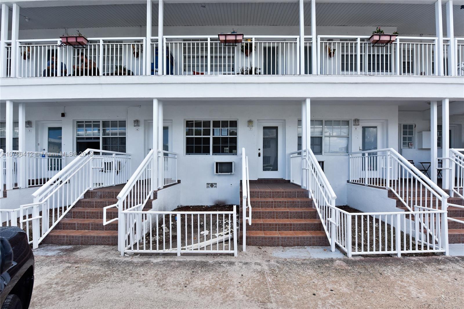 330 74th Street, Unit 7 Miami Beach, FL 33141 - Photo 1 of 27 front view of a house with a deck and a fence