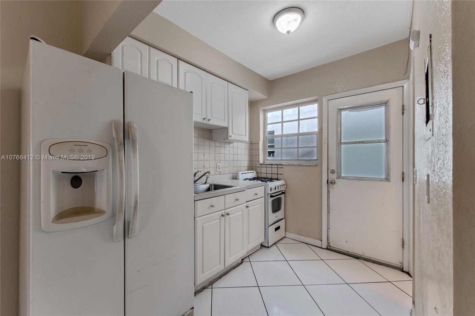 330 74th Street, Unit 7 Miami Beach, FL 33141 - Photo 10 of 27 a kitchen with stainless steel appliances a refrigerator sink and cabinets
