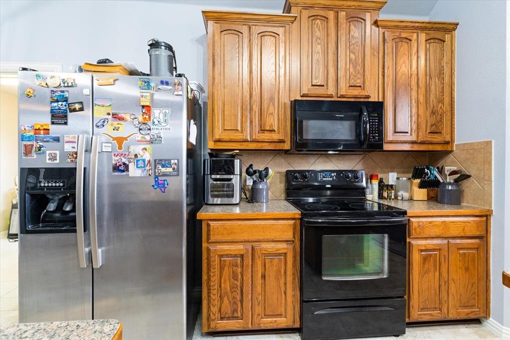 5366 Tree Grace Lane Kaufman, TX 75142 - Photo 10 of 33 a kitchen with stainless steel appliances granite countertop a stove top oven