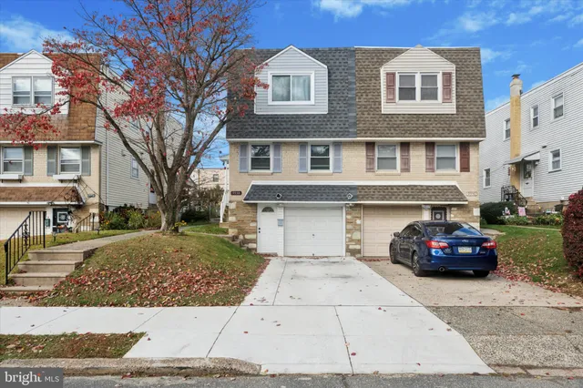 a black car parked in front of a brick house