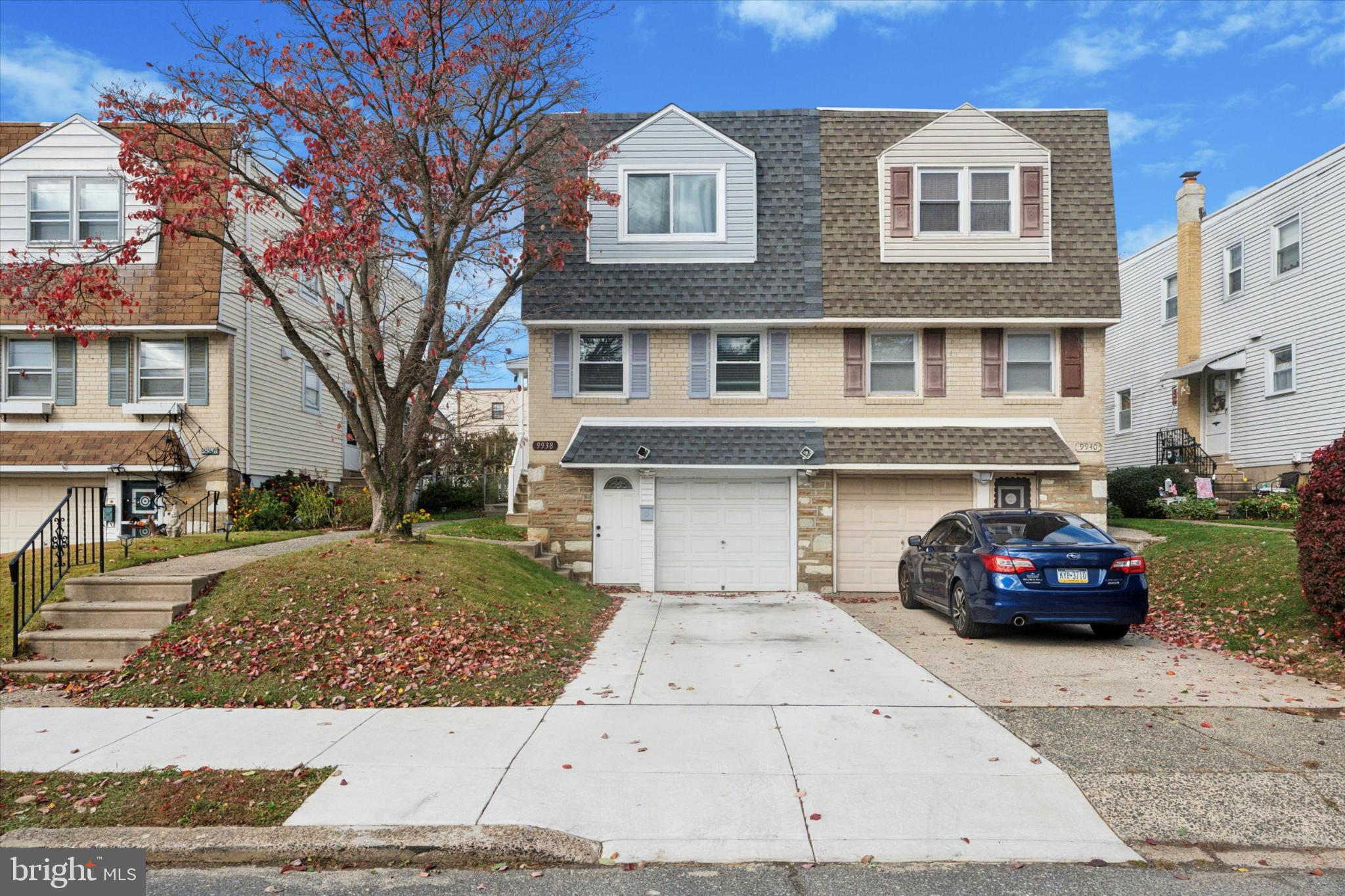 a black car parked in front of a brick house