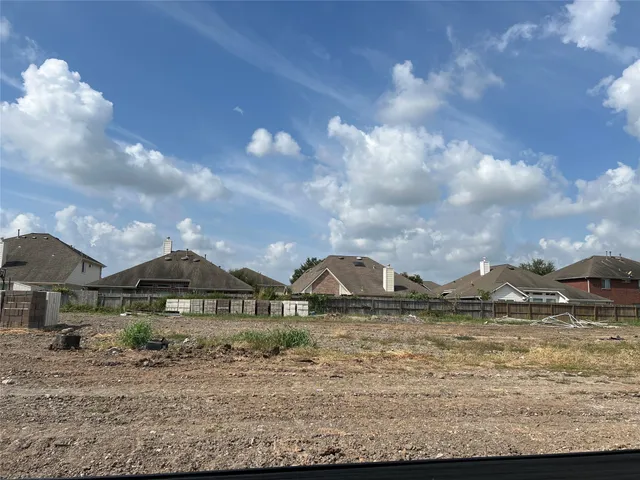 a view of a house with a big yard and large tree