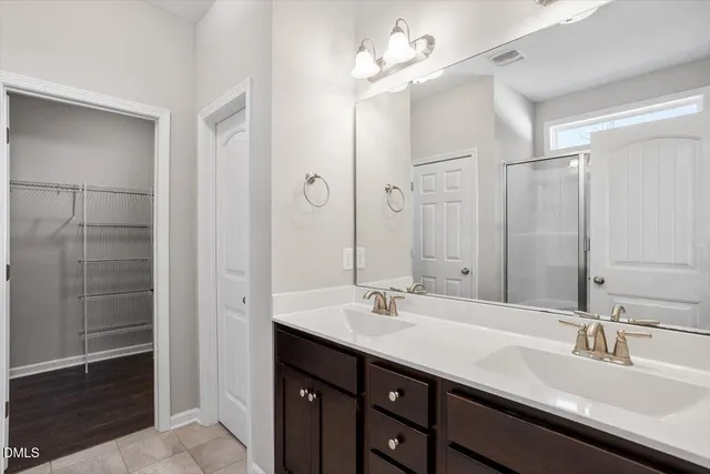 a bathroom with a double vanity sink a mirror and a shower