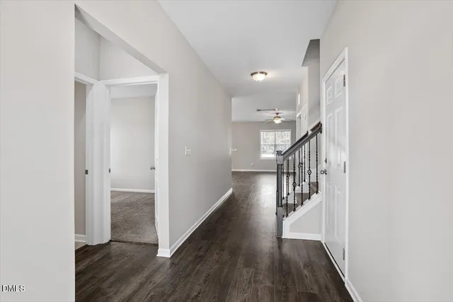 a view of a hallway with wooden floor and staircase