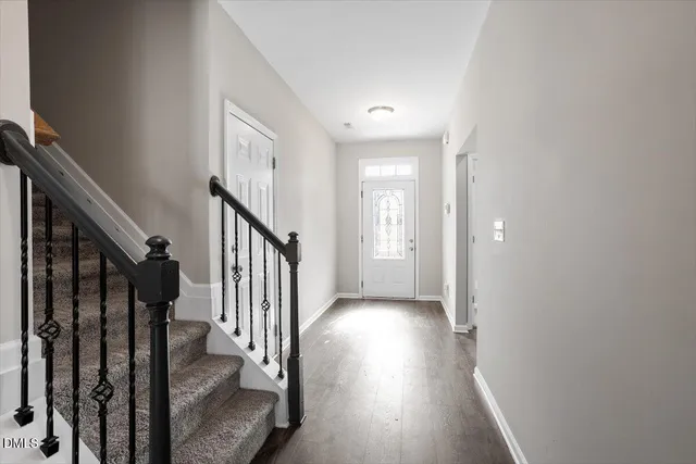 a view of a hallway with wooden floor and staircase