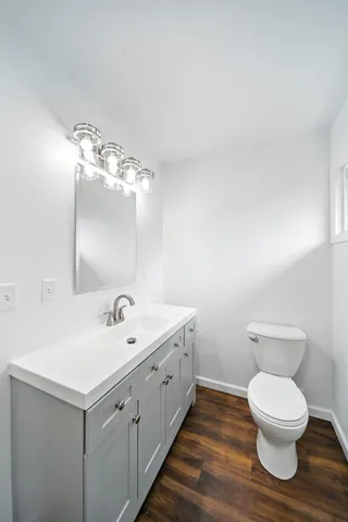 a spacious bathroom with a toilet sink and mirror