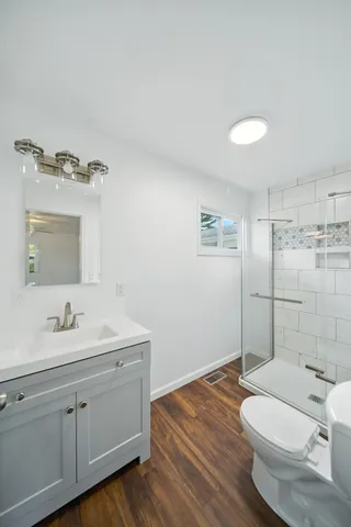 a bathroom with a toilet a sink and mirror