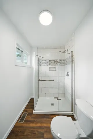 a bathroom with a toilet and a shower