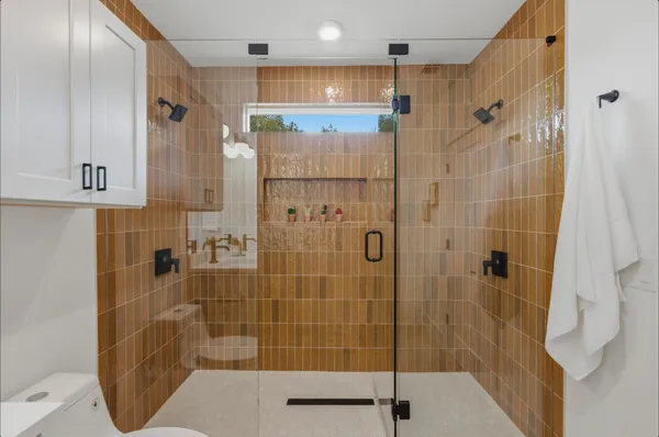 a bathroom with a double vanity sink toilet and shower