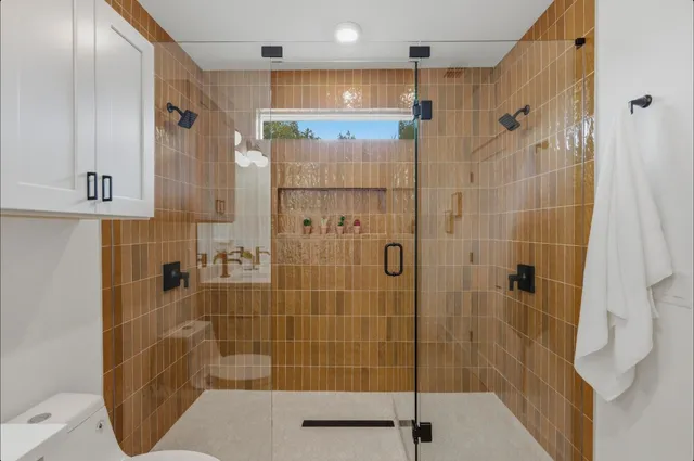 a bathroom with a double vanity sink toilet and shower