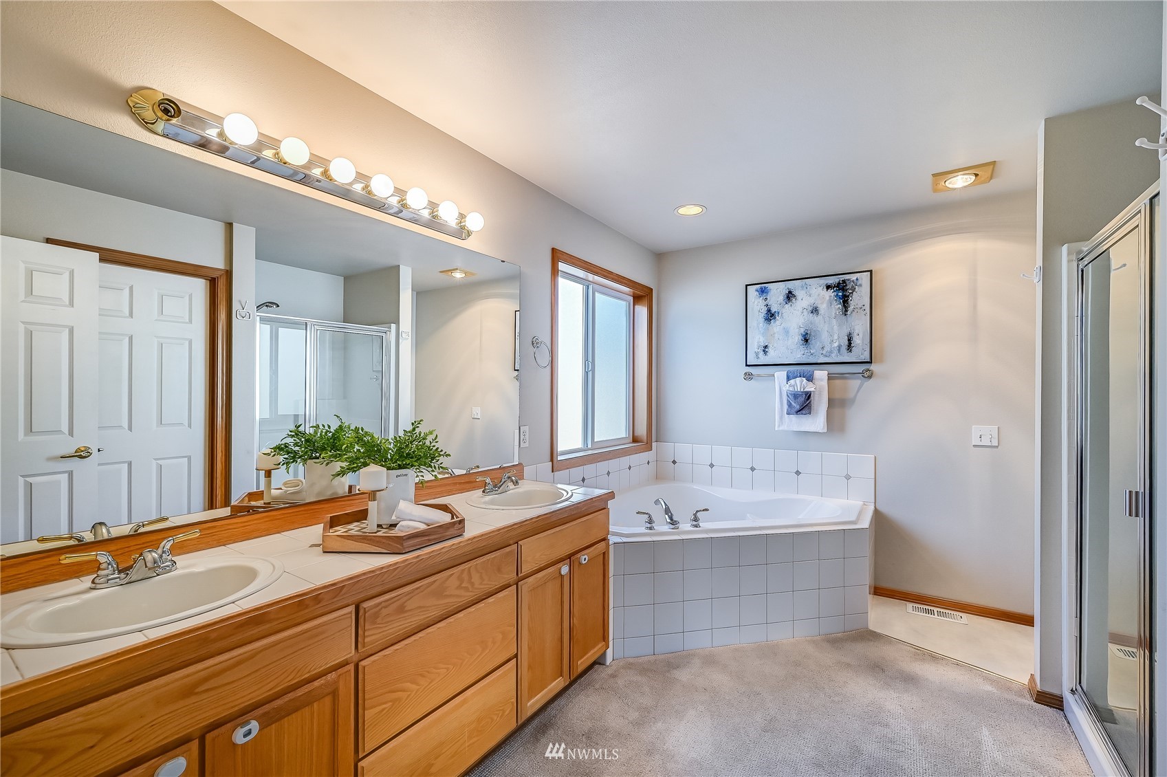 1125 185th Place Southeast Bothell, WA 98012 - Photo 13 of 23 a spacious bathroom with a double vanity sink a large mirror and a bathtub