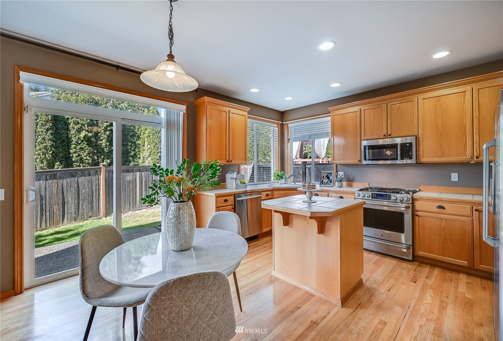 1125 185th Place Southeast Bothell, WA 98012 - Photo 8 of 23 a kitchen with stainless steel appliances granite countertop a stove a sink a microwave a dining table and chairs