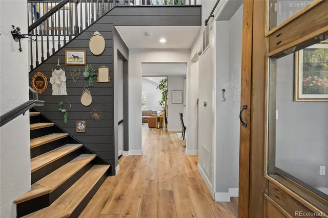 a view of a hallway with wooden floor and staircase