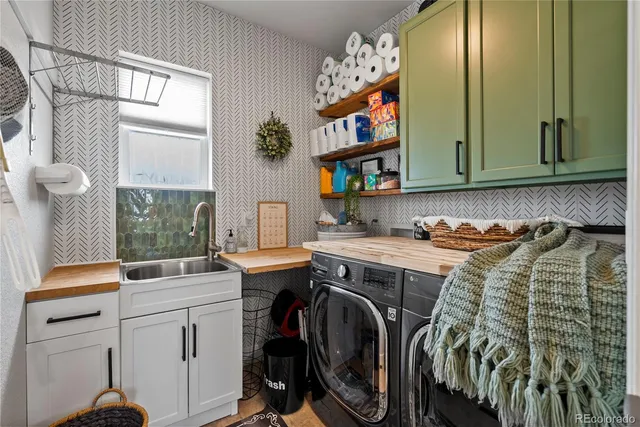 a utility room with cabinets a washer and dryer on the counter